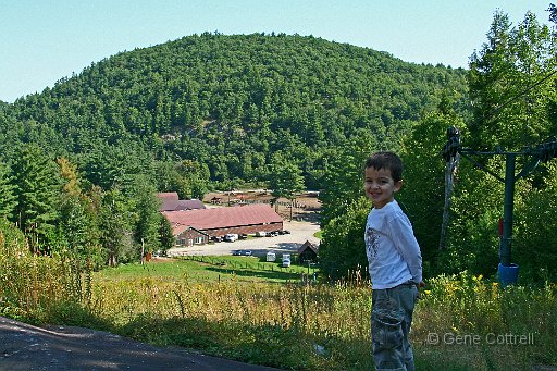 MaxHill.jpg - Max, at the top of the ski slope with a view of the arena and barns below.